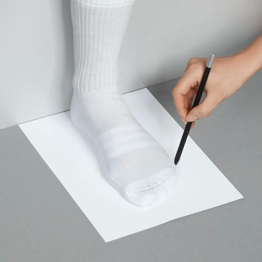 Place your longest foot on the paper with your heel firmly against the wall